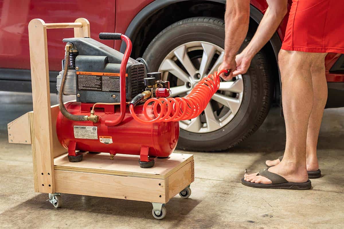 Air compressor on cart airing up tire